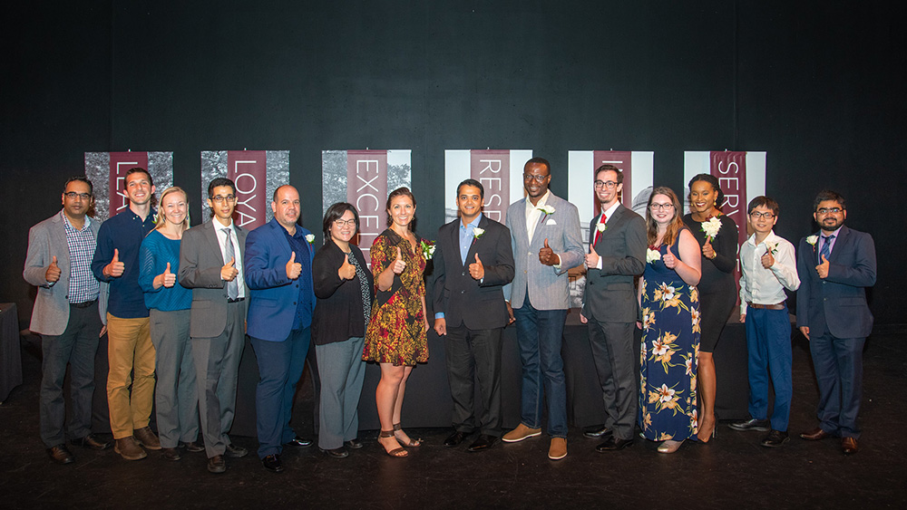 14位2019年杰出学生奖获得者的合影。所有人都竖起大拇指。