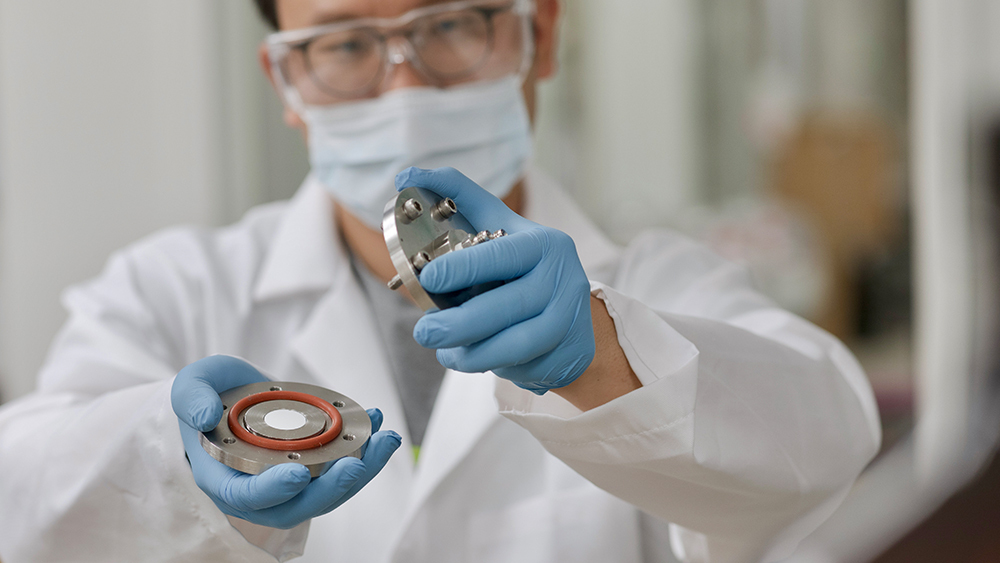 一名男学生在实验室里拿着一个装有聚酰亚胺膜的平台。