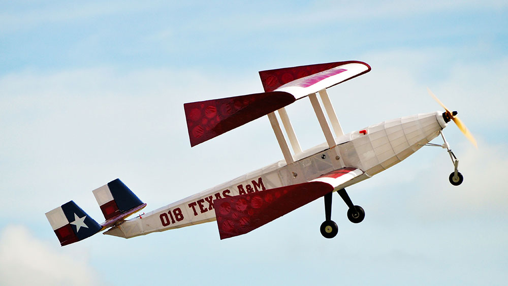 红、白、蓝三色德州旗主题双翼遥控飞机飞行。