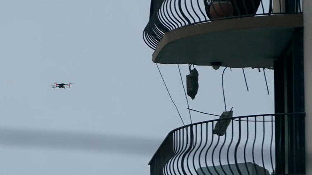 飞行中的无人机正在检查尚普兰塔南公寓大楼剩余部分的上层。