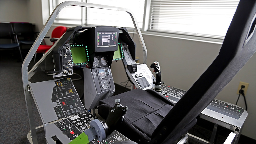 一个铝制框架的飞行模拟器，配备了手动油门和摇杆控制装置，一个多功能显示器，拨动开关和复制F16布局的贴纸。