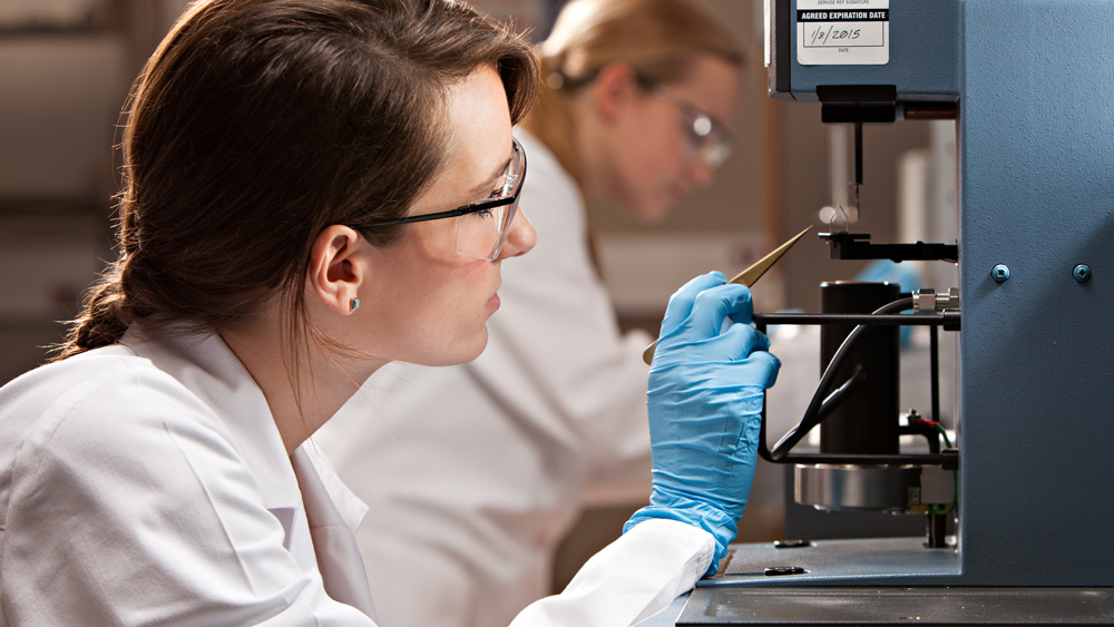 德州农工大学的生物医学工程实验室里，两名穿着防护装备的女研究生正在使用设备