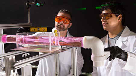 两个身穿实验室大褂的核科学家在看一个实验。