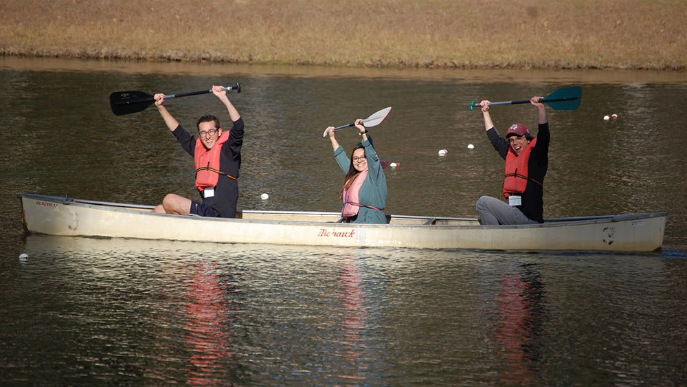 扎克里领导力项目的学生坐在独木舟上，举起桨
